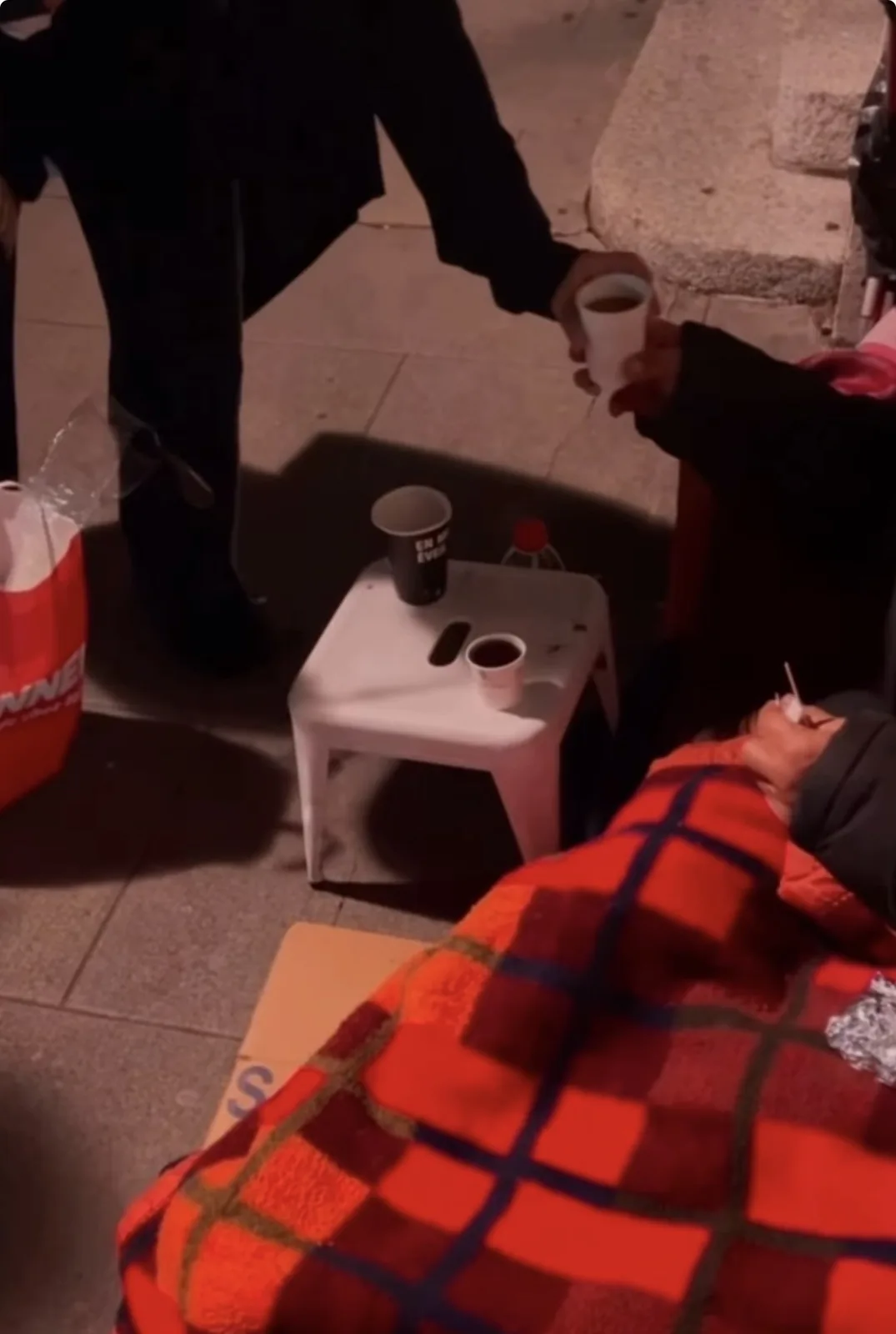 Distribution d'une boisson chaude à une personne sans-abri